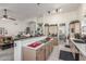 Open kitchen with bar, cooktop island, neutral cabinetry, and seamless living area access at 17543 N Rainbow Cir, Surprise, AZ 85374