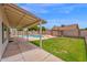 Covered patio with a spacious backyard featuring a sparkling pool, grass area, and privacy wall at 1755 N 74Th Pl, Mesa, AZ 85207