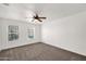 Spacious bedroom with neutral carpeting, ceiling fan, and natural light from large windows at 1755 N 74 Th Pl, Mesa, AZ 85207