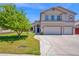 Spacious two-story home with a three-car garage, well-maintained lawn, and mature tree at 1755 N 74 Th Pl, Mesa, AZ 85207