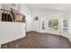 Bright foyer boasts wood-look floors, a staircase with wood railing, and ample natural light from front windows at 1755 N 74 Th Pl, Mesa, AZ 85207