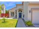Charming single-story home with a well-manicured lawn, blue front door, and a two-car garage at 1755 N 74 Th Pl, Mesa, AZ 85207