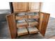 Spacious pantry featuring wooden cabinets with pull-out shelving for organized kitchen storage at 1755 N 74Th Pl, Mesa, AZ 85207