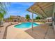 Inviting pool area with covered patio, perfect for outdoor enjoyment and relaxation amidst mature trees and lush greenery at 1755 N 74Th Pl, Mesa, AZ 85207