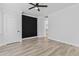 Bright bedroom features wood-look floors, black accent wall, and a ceiling fan at 18998 E Lark Dr, Queen Creek, AZ 85142
