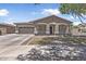 Inviting single-story home featuring desert landscaping, a two-car garage, and shaded front porch at 18998 E Lark Dr, Queen Creek, AZ 85142