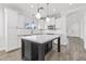 Bright kitchen features an island, modern appliances, white cabinets, and stylish pendant lighting at 18998 E Lark Dr, Queen Creek, AZ 85142