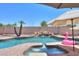 Inviting pool and spa featuring a rock waterfall, tropical plants, and a whimsical flamingo float at 2041 E Palm Beach Dr, Chandler, AZ 85249