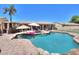 Sparkling pool with stone surround, outdoor kitchen, umbrellas and lounge area creates a backyard paradise at 2041 E Palm Beach Dr, Chandler, AZ 85249
