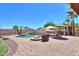 Backyard oasis featuring a pool, waterfall, lounge area, fire pit, outdoor kitchen, and tropical landscaping at 2041 E Palm Beach Dr, Chandler, AZ 85249