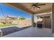 View of covered patio with ceiling fan overlooking grassy area and barbecue at 22682 E Indiana Ave, Queen Creek, AZ 85142