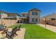 Spacious backyard with green grass and black Adirondack chairs near a fire pit at 22682 E Indiana Ave, Queen Creek, AZ 85142