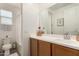 A stylish bathroom featuring wood cabinets, white countertops, and a shower with a white curtain at 22682 E Indiana Ave, Queen Creek, AZ 85142