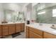 Elegant bathroom features double vanity sinks, wood cabinetry, and a separate glass-enclosed shower area at 22682 E Indiana Ave, Queen Creek, AZ 85142