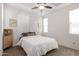A bedroom featuring a ceiling fan and a neutral palette, complemented by the natural light from the large window at 22682 E Indiana Ave, Queen Creek, AZ 85142