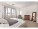 Bright bedroom with large windows, neutral decor, a bed, dresser, and a comfortable armchair at 22682 E Indiana Ave, Queen Creek, AZ 85142