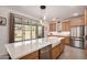 Well-lit kitchen featuring stainless steel appliances, wood cabinets, an island sink, and sliding doors to the backyard at 22682 E Indiana Ave, Queen Creek, AZ 85142