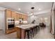 Spacious kitchen includes stainless steel appliances, wooden cabinets, a center island with seating, and an open dining area at 22682 E Indiana Ave, Queen Creek, AZ 85142