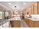 Bright kitchen features wooden cabinets, a large center island with countertop, stainless steel appliances, and sliding glass doors at 22682 E Indiana Ave, Queen Creek, AZ 85142
