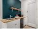 This kitchenette boasts a wood countertop, a mini fridge, a shelf, and a decorative navy accent wall at 22682 E Indiana Ave, Queen Creek, AZ 85142