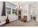 Bright sitting room with neutral walls and carpet, large windows, built-in bookcase, and chair at 22682 E Indiana Ave, Queen Creek, AZ 85142