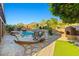Cozy backyard area with a custom pool, spa, built-in fireplace, and mature landscaping at 24645 N 65Th Ave, Glendale, AZ 85310
