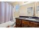 Bathroom features a vanity with dark wood cabinets and granite countertop and a shower-tub combo at 24645 N 65Th Ave, Glendale, AZ 85310