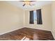 Bedroom with wood-look floors, a ceiling fan, and a window with dark curtains at 24645 N 65Th Ave, Glendale, AZ 85310