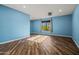Bright bedroom with wood-style floors and backyard view from the window at 24645 N 65Th Ave, Glendale, AZ 85310