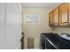 Functional laundry room with upper cabinets and modern washer and dryer at 24645 N 65Th Ave, Glendale, AZ 85310