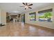 Open concept living area with tile flooring, ceiling fan and kitchen access with barstool seating at 24645 N 65Th Ave, Glendale, AZ 85310