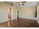 Spacious main bedroom with wood-look floors, ceiling fan, and doorway to bathroom at 24645 N 65Th Ave, Glendale, AZ 85310