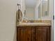 Cozy powder room with wood cabinets, granite countertop and brushed bronze fixtures at 24645 N 65Th Ave, Glendale, AZ 85310