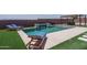 Inviting backyard featuring a sparkling pool with a water feature, lounge chairs, and a dining area at 25560 N 164Th Dr, Surprise, AZ 85387