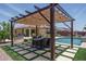 Spacious backyard featuring a pool, pergola-covered dining area, and comfortable seating, perfect for outdoor living at 25560 N 164Th Dr, Surprise, AZ 85387
