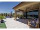 Spacious covered patio with tile flooring, comfortable seating, and lush landscaping, perfect for outdoor living and dining at 25560 N 164Th Dr, Surprise, AZ 85387