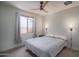 Cozy bedroom featuring a ceiling fan, window with curtains, and sconces for ambient lighting at 25560 N 164Th Dr, Surprise, AZ 85387