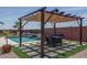 Beautiful outdoor pool and pergola area featuring a dining area, lounge chairs, and waterfall feature at 25560 N 164Th Dr, Surprise, AZ 85387