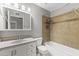 Bathroom features a shower-tub combo with tan tiling, white vanity and toilet, and a mirrored medicine cabinet at 2633 E Garnet Ave, Mesa, AZ 85204