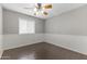 A bright bedroom with wood-look floors, chair rail, and a ceiling fan offers a comfortable living space at 2633 E Garnet Ave, Mesa, AZ 85204