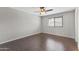 A simple bedroom with wood-look floors and a ceiling fan with lights, offers a clean and neutral space at 2633 E Garnet Ave, Mesa, AZ 85204
