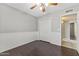 Well-lit bedroom featuring wood-look floors, chair rail, a ceiling fan and direct access to the hallway at 2633 E Garnet Ave, Mesa, AZ 85204