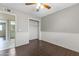 Bedroom featuring wood-look floors, chair rail, ceiling fan, closet, and access to the bathroom and hallway at 2633 E Garnet Ave, Mesa, AZ 85204