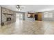 Spacious living room featuring tile flooring, a brick fireplace, open layout, and seamless connection to the kitchen at 2633 E Garnet Ave, Mesa, AZ 85204