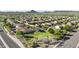 Expansive aerial view of a residential neighborhood surrounded by lush greenery and mountain views at 29302 N 126Th Ln, Peoria, AZ 85383