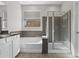 Bright bathroom featuring a soaking tub, glass-enclosed shower, and modern finishes at 29302 N 126Th Ln, Peoria, AZ 85383