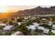 Panoramic aerial view of a vibrant neighborhood surrounded by lush greenery and majestic mountains at sunset at 3186 E Stella Ln, Phoenix, AZ 85016