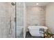 Elegant bathroom featuring a freestanding tub with stone accent wall and a glass-enclosed shower at 3186 E Stella Ln, Phoenix, AZ 85016