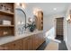 Stylish bathroom featuring dual sinks, wood cabinetry, decorative mirrors, and modern fixtures at 3186 E Stella Ln, Phoenix, AZ 85016