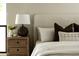 Close-up of bedside table, lamp, and bed with throw pillows for a cozy design at 3186 E Stella Ln, Phoenix, AZ 85016